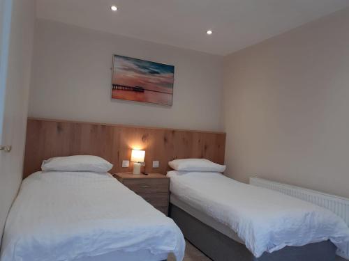 a bedroom with two beds and a lamp on a table at THE FORTWELL BOARDING HOUSE in Letterkenny