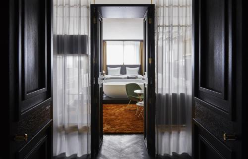 a view of a room with a bed and a window at Roomers Munich, Autograph Collection in Munich