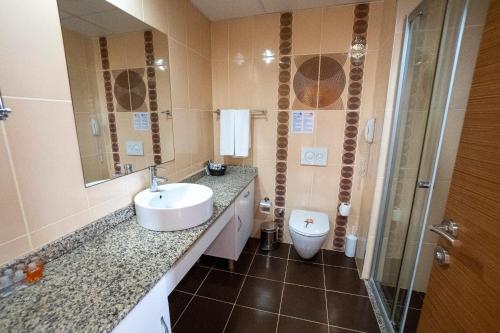 y baño con lavabo y aseo. en Cenger Beach Resort Spa - All Inclusive, en Kızılot