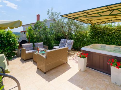 eine Terrasse mit einem Whirlpool, Stühlen und einer Whirlpool-Badewanne. in der Unterkunft Holiday Home Nevena in Buje