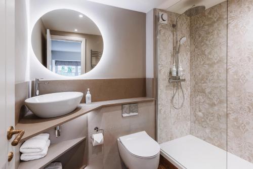 a bathroom with a sink and a toilet and a mirror at Coffee & Stays at Cartmel Square in Cartmel
