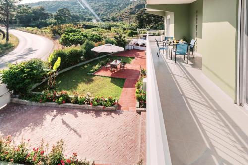 a balcony with a table and chairs and a garden at Greek Style Apartment with Jaquzzi & Barbeque in Triánta