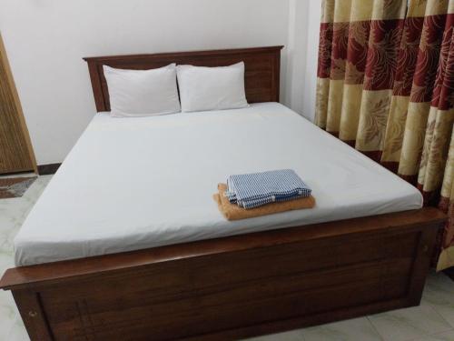 a bed with a white mattress and a basket on it at Sea Side Bay House in Weligama