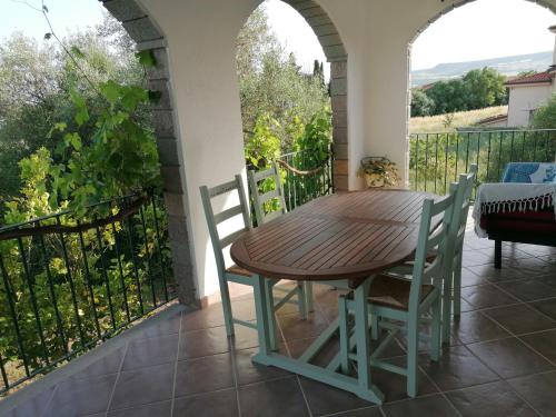 a wooden table and chairs on a balcony at La casa degli ulivi in Turri