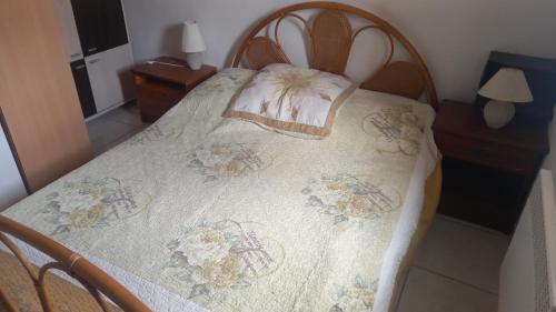 una camera da letto con un letto con copriletto floreale di St Pierre la Mer maison 3 chambres 6 couchages a Saint Pierre La Mer