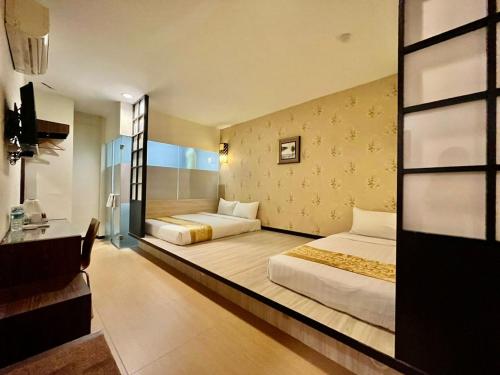 una camera d'albergo con due letti e un bagno di Eight Days Boutique Hotel - Impian Emas a Skudai