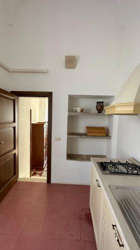 a kitchen with white walls and a stove top oven at La Dimora Del Barone in Vernole