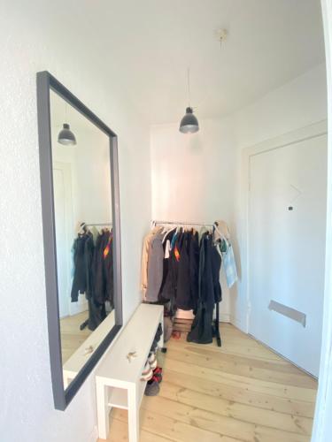 a dressing room with a mirror and clothes racks at beautiful danish apartment on the beach with 2 free bikes in Copenhagen