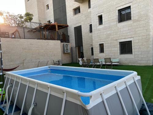 una piscina en el patio trasero de un edificio en דירת גן מהממת בבית שמש en Bet Shemesh