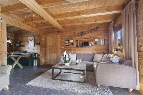 sala de estar con sofá y mesa en Tradisjonell laftet hytte en Vradal