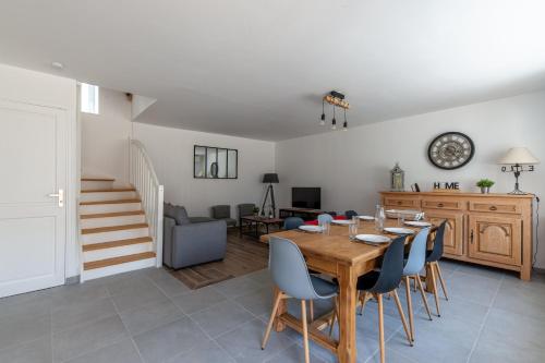 une salle à manger et un salon avec une table et des chaises dans l'établissement Gîte du Tilleul - Maison climatisée pour 8 voyageurs, à Houesville