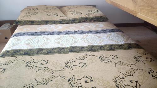 een bed in een slaapkamer met een sprei en kussens bij Location maison de vacances Sancerre in Sancerre