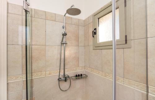 een douche met een glazen deur in de badkamer bij Villa Eva in Ágios Stéfanos