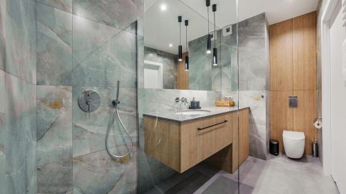 a bathroom with a sink and a shower at Apartamenty Sun & Snow Baltea in Gdańsk