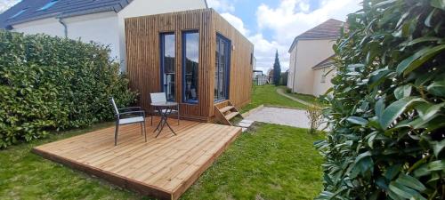 ein winziges Haus auf einer Holzterrasse im Hof in der Unterkunft L'Ôasis du Désert in Ormes