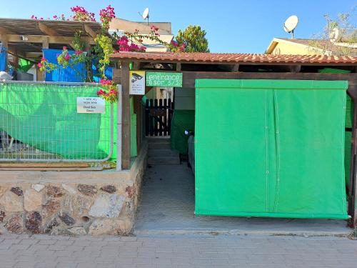 una puerta verde frente a un edificio en נווה מדבר - אירוח מקומי, en Arad