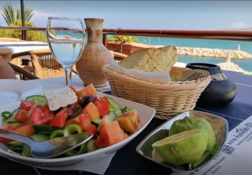 - une table avec une assiette de nourriture et un verre de vin dans l'établissement Shambala Beach House-where mountains meet the sea, à Pomos