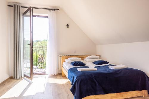 ein Schlafzimmer mit einem Bett und einem großen Fenster in der Unterkunft Czarna Góra Apartamenty TATRY GÓRY BIAŁKA T BUKOWINA T ZAKOPANE in Czarna Góra