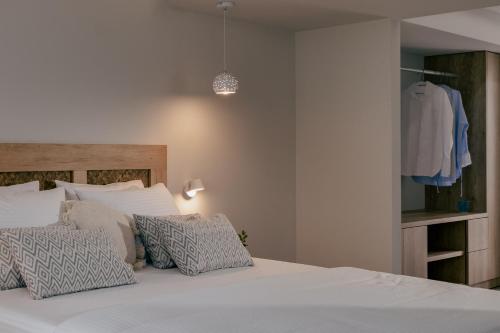 a bedroom with a bed with white sheets and pillows at Anassa Suites Stalis by Estia "Adults Only" in Stalida