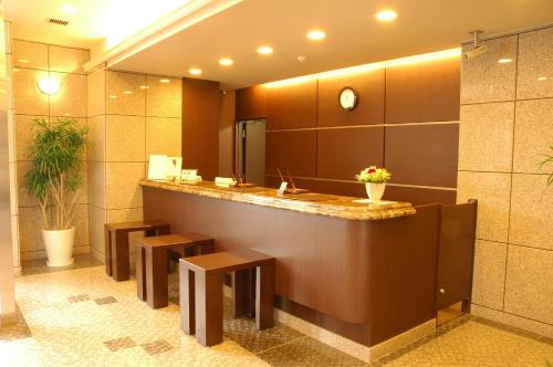 a lobby with a counter with benches and a mirror at Hotel Route-Inn Hirosaki Ekimae in Hirosaki