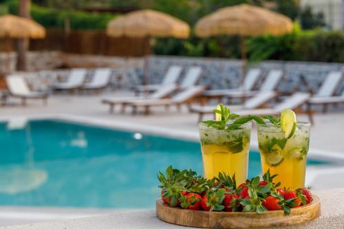 two drinks on a tray next to a pool at Anassa Suites Stalis by Estia "Adults Only" in Stalida