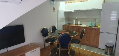 cocina con mesa y sillas y TV en Bella Ciao, en Vrnjačka Banja