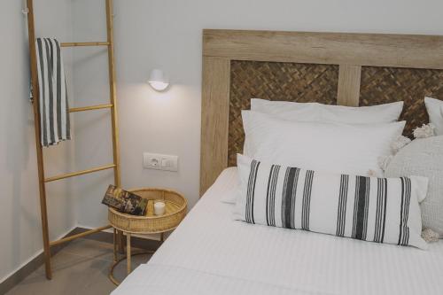 a bedroom with a white bed with a wooden headboard at Anassa Suites Stalis by Estia "Adults Only" in Stalida