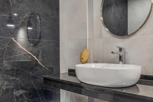 a bathroom with a white sink and a mirror at Anassa Suites Stalis by Estia "Adults Only" in Stalida
