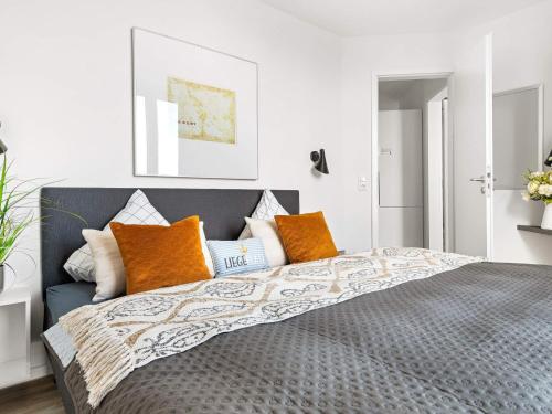 a bedroom with a bed with orange and white pillows at Apartment Wendtorf XXXI in Wendtorf