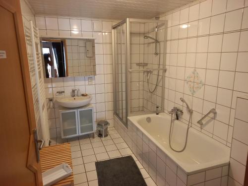 ein Bad mit einer Badewanne, einem Waschbecken und einer Dusche in der Unterkunft Ferien im Winzerhaus in Traben-Trarbach