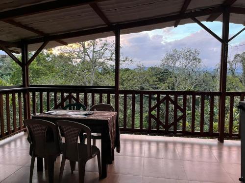 a table and chairs on a screened in porch with a view at Waka Maru in San Agustín