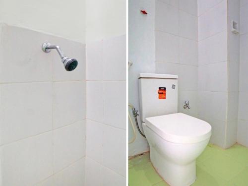 een badkamer met een wit toilet en een douche bij OYO 92429 Vania Guest House in Medan