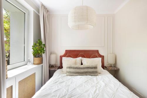 ein Schlafzimmer mit einem Bett und einer Hängeleuchte in der Unterkunft Elite Apartments Beachfront in Danzig