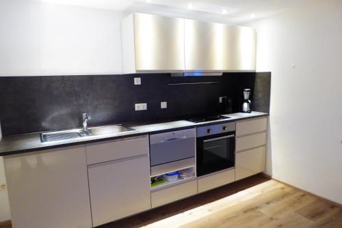 a kitchen with stainless steel appliances and a sink at Ferienwohnung am Bacherl in Surberg