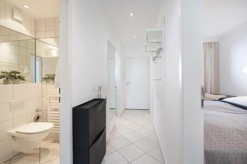 - une salle de bains blanche pourvue de toilettes et d'un lit dans l'établissement Miramar Wohnung 510, à Grömitz