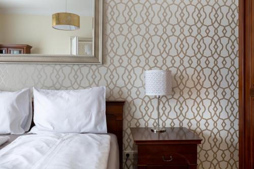 a bedroom with a bed and a mirror and a lamp at GDE Károly Apartmant in Budapest