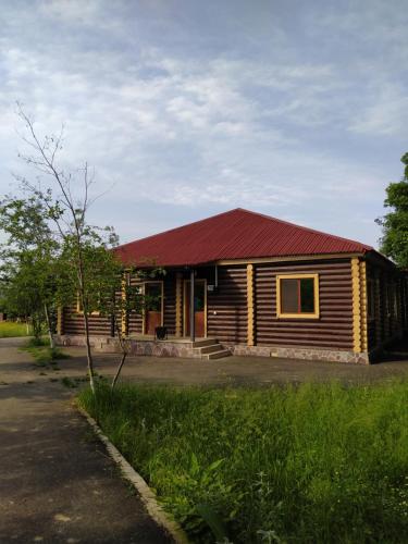 a small wooden cabin with a red roof at Qusar Qala Hotel in Qusar