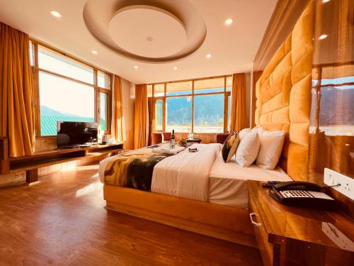 Hill River Resort - Central Heated & Air cooled في مانالي: غرفة نوم بسرير كبير في غرفة بها نوافذ