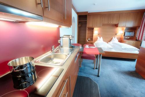 a kitchen with a sink and a bed in a room at Appartement Désirée inkl der SUPER SOMMER CARD im SOMMER 2025 in Serfaus