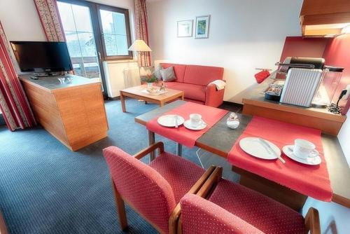 a living room with a red table and chairs at Appartement Désirée inkl der SUPER SOMMER CARD im SOMMER 2025 in Serfaus