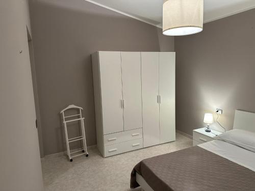 a bedroom with a bed and a white cabinet at Le Palme di Riace 1 in Riace Marina
