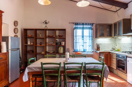 Una cocina con una mesa con sillas y un refrigerador. en Podere Par di Rota, en Calci