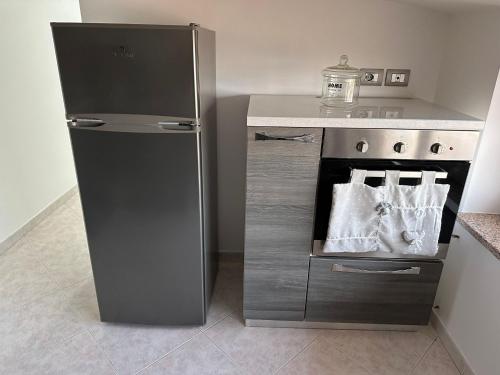 a kitchen with a stainless steel refrigerator next to a stove at Le Palme di Riace 1 in Riace Marina