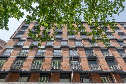 un edificio alto de ladrillo con muchas ventanas en numa I Verso Apartments, en Roma
