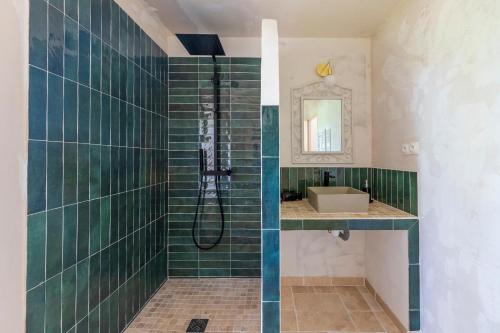 une douche carrelée verte avec un lavabo et un miroir dans l'établissement La Pampa en Provence - Maison de vacances, à Pontevès
