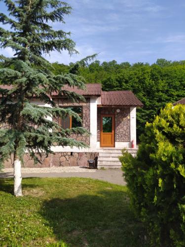 a small house with a red door in a yard at Qusar Qala Hotel in Qusar