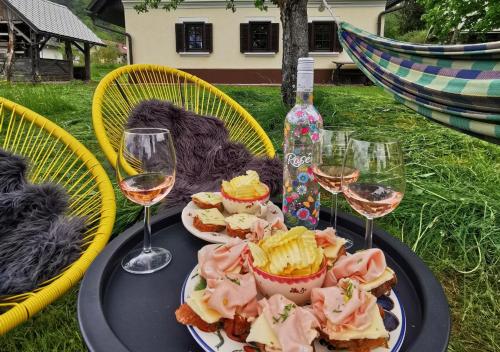 a table with a plate of food and glasses of wine at Country House Pri Lipet Žiri in Žiri