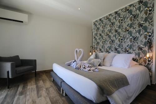 a bedroom with a bed with a large headboard at Hôtel confidentiel Le Grecale in Pianottoli-Caldarello