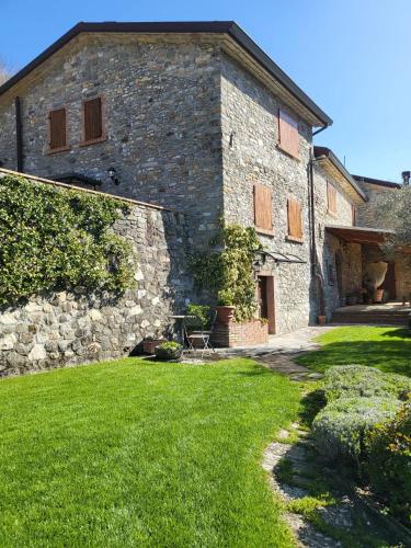 ein großes Steingebäude mit einem Rasenhof in der Unterkunft Old Village Linda - Tra Lunigiana & Cinque Terre in Comano