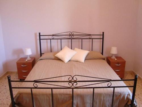サント・ステーファノ・ディ・カマストラにあるCasa Vacanze U Pignuのベッドルーム1室(大型ベッド1台、ナイトスタンド2台付)